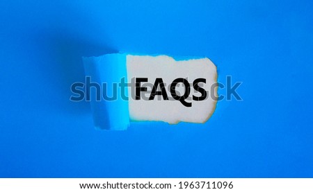 FAQS, frequently asked questions symbol. Concept words 'FAQS, frequently asked questions' appearing behind torn blue paper. Beautiful blue background, copy space. Business and FAQS concept.