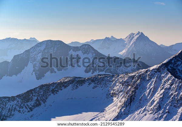 Far away\
mountain peaks in the sunrise seen from the vantage point at the\
mountain station of the Wildspitz cable\
car