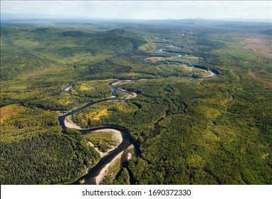far east taiga view from helicopter. Winding forest river top view. wild siberian landscape. far east taiga views from helicopter. Green color  forest along the banks of forest river