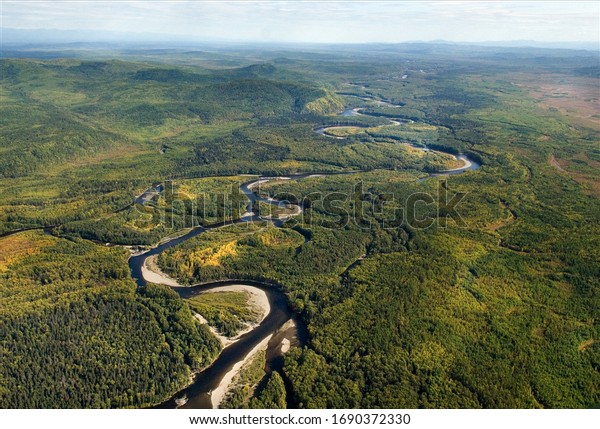far\
east taiga view from helicopter. Winding forest river top view.\
wild siberian landscape. far east taiga views from helicopter.\
Green color  forest along the banks of forest\
river