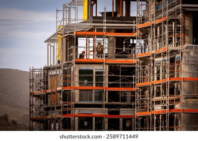 Far shot of a construction worker working in a large commercial building under contruction