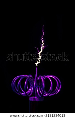 faraday , Tesla Coil, Experiments and Induction of Electric Current. The Origin of Lightning. Black background, copyspace