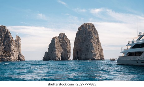 Faraglioni Rock Formation and Yacht on the Blue Waters of Capri, Italy – A Stunning Coastal View - Powered by Shutterstock