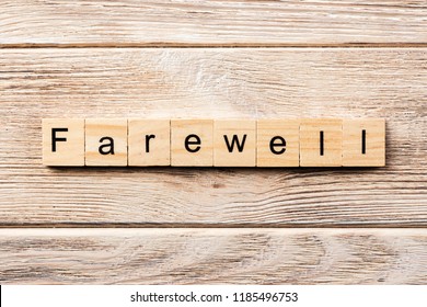 farewell word written on wood block. farewell text on table, concept.