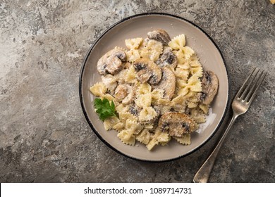 farfalle pasta with champignon mushrooms and garlic creamy sauce on pan,  top view - Powered by Shutterstock