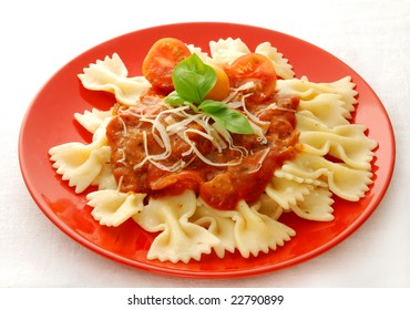 Farfalle with tomato sauce on red plate