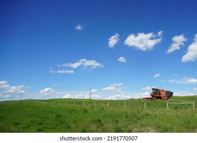 Farm Equipment On Vast Prairie Field