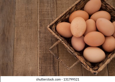 Farm Fresh Brown Chicken Hen Eggs in a Basket on Rustic Wood Counter  Background with Copyspace, Horizontal