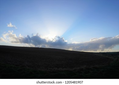 Farm Land Prepared For Winter And The Sun Shinning Through Clouds Above, Cornwall, England