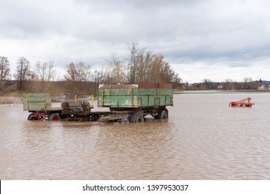 Farm machinery on a field flooded by high water of a small river in spring
