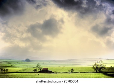 Farm In The Middle Of Farmland And Fields - A Shaft Of Light After A Passing Storm Near Shap, Cumbria, England Uk