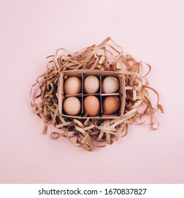 Farm Organic Eggs In A Wooden Basket And Paper Pack Decor On Pastel Pink Background. Zero Waste, Easter Concept. Flat Lay Style.