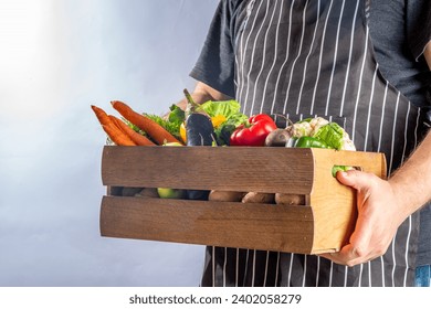 Farm organic market shopping concept, Wooden box with summer, autumn raw vegetables and fruits, in farmer mans hands on white background - Powered by Shutterstock