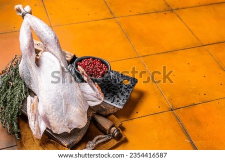 Farm Raw Guineafowl, guinea fowl with herbs ready for cooking. Orange background. Top view. Copy space.