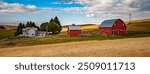 A farm with a red barn beside a wheat field in the Palouse country, eastern Washington