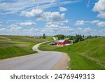 Farm with a red barn on a curving road in the Iowa countryside on a beautiful spring day