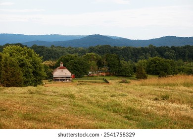 Farm scene in the Shenandoah Valley with barn and rolling hills. Green grass. Wooden fence. - Powered by Shutterstock