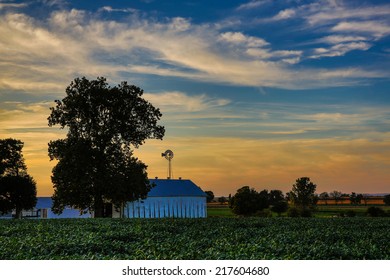 Farm At Sunset With Tobacco Field In Foreground.