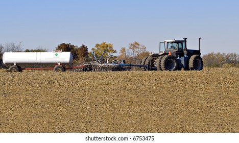 Farm Tractor Pulling A Plow And A Nurse Tank Of Anhydrous Ammonia Fertilizer