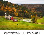 Farm in valley of hills during Fall with autumn colors showing on a dreary evening low contrast from a high angle above on the hill