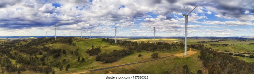 A farm of wind turbines high on hill range top generating renewable energy in NSW, Australia, along Hume Highway.