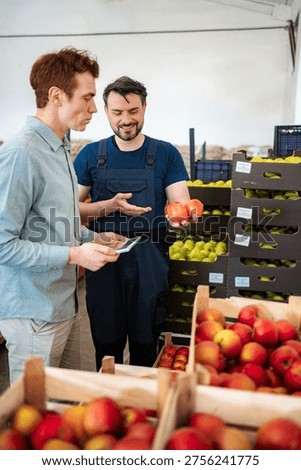 Farm worker and inspector checking organic produce quality