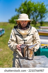 Farmer In Bee Costume Workiing With Beehives. Beekeeper Man In Protective Costume.