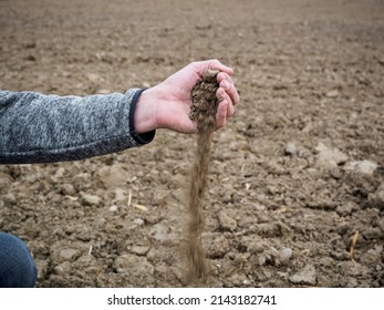 A Farmer Checks The Dry Soil In A Field. Drought Climate Section.