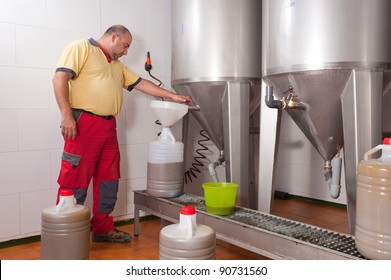 Farmer collecting the freshly pressed oil from his olive crop - Powered by Shutterstock