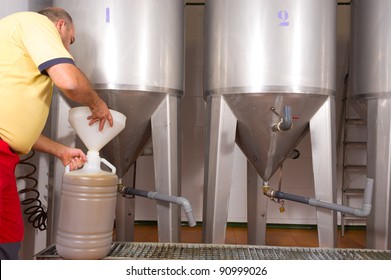Farmer collecting the freshly pressed oil from his olive crop