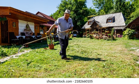 A Farmer Is Cutting Gras With A Sense In Oncesti Romania, July 07, 2022