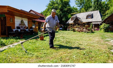 A Farmer Is Cutting Gras With A Sense In Oncesti Romania, July 07, 2022