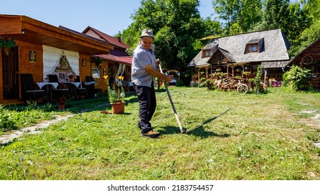 A Farmer Is Cutting Gras With A Sense In Oncesti Romania, July 07, 2022