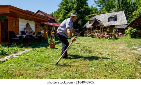 A Farmer Is Cutting Gras With A Sense In Oncesti Romania, July 07, 2022