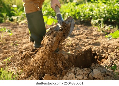 Farmer digging soil with shovel on sunny day, closeup - Powered by Shutterstock