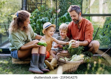 Farmer family with fresh harvest sitting in a greenhouse - Powered by Shutterstock