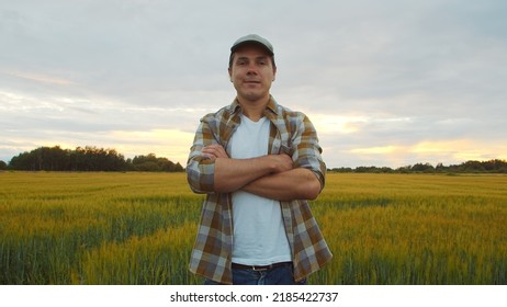 Farmer In Front Of A Sunset Agricultural Landscape. Man In A Countryside Field. Country Life, Food Production, Farming And Country Lifestyle.