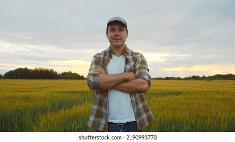 Farmer In Front Of A Sunset Agricultural Landscape. Man In A Countryside Field. Country Life, Food Production, Farming And Country Lifestyle.