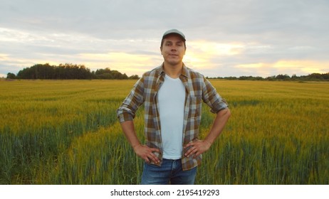 Farmer In Front Of A Sunset Agricultural Landscape. Man In A Countryside Field. Country Life, Food Production, Farming And Country Lifestyle.