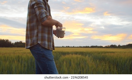 Farmer In Front Of A Sunset Agricultural Landscape. Man In A Countryside Field. Country Life, Food Production, Farming And Country Lifestyle.