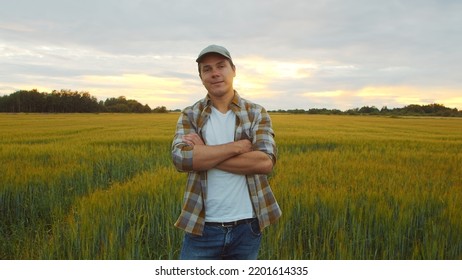 Farmer In Front Of A Sunset Agricultural Landscape. Man In A Countryside Field. Country Life, Food Production, Farming And Country Lifestyle.