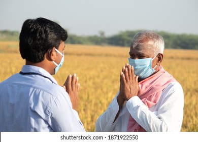 Farmer Greeting To Banker Or Corporate Government Officer By Doing Namaste While Both Worn Face Mask Due To Coronavirus Covid-19 Pandemic Meeting Near Agriculture Farmland