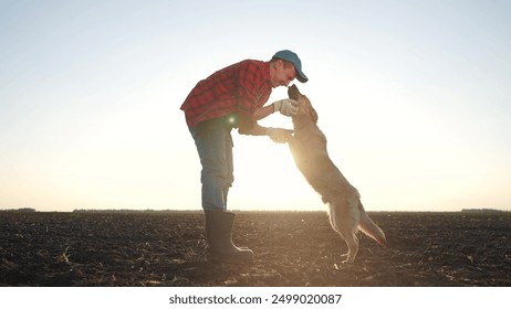 Farmer and his dog play together in field. farming is the concept of caring for pet. a man and his dog are in friendship together. a man and a dog playing together in a field lifestyle. - Powered by Shutterstock