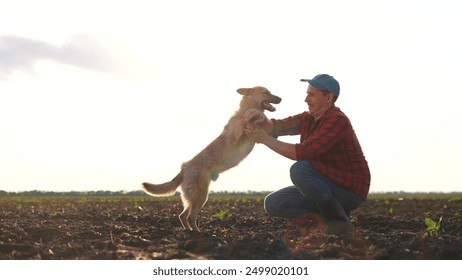 Farmer and his dog play together in field. farming is the concept of caring for pet. a man and his dog are in friendship together. a lifestyle man and a dog playing together in a field. - Powered by Shutterstock