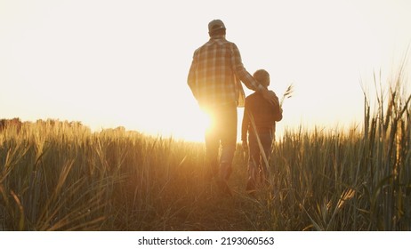 Farmer and his son in front of a sunset agricultural landscape. Man and a boy in a countryside field. Fatherhood, country life, farming and country lifestyle. - Powered by Shutterstock