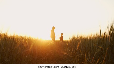 Farmer and his son in front of a sunset agricultural landscape. Man and a boy in a countryside field. Fatherhood, country life, farming and country lifestyle. - Shutterstock ID 2201357559