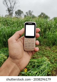 Farmer Holding Keypad Mobile Phone In Hand With Blank White Screen