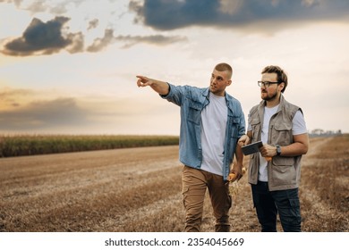 Farmer and inspector are standing in the field in countryside. - Powered by Shutterstock