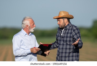 Farmer And Insurance Sales Rep Representative Discussing Arguing Explainging. Two Men Talking Not Understanding Holding Clipboard Shrugging.