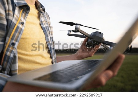 Farmer with laptop and drone on the field. Smart farming and agriculture digitalization